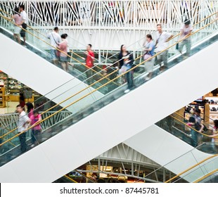 People In Motion In Escalators At The Modern Shopping Mall.