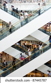 People In Motion In Escalators At The Modern Shopping Mall.