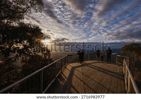 People observing the view at a cool spring sunrise from Boroka Lookout towards Halls Gap and Lake Bellfield in the Grampians, Victoria, Australia