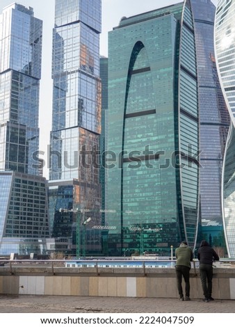 People on the background of skyscrapers. Modern architecture. Made of glass and concrete. Beautiful  new skyscrapers. High-rise buildings in Moscow. Many windows. Moscow City