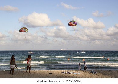 People On Beach And In The Sea, With Boats And Parasail Kites In The Background, South Beach, Miami, Florida, March 3, 2012