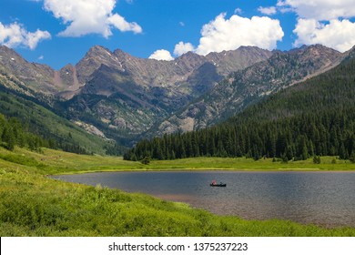 People On A Canoe In A Lake In The Colorado Rocky Mountains Of Vail In Summer At Calm Piney Lake