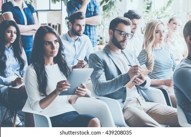 People on conference. Group of young people sitting on conference together and making notes - Powered by Shutterstock