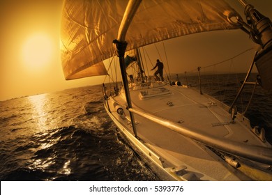 People On A Sail Boat At The Sunset