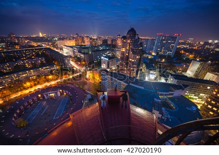 People on the top of roof, night view of Kiev, the lights beautiful