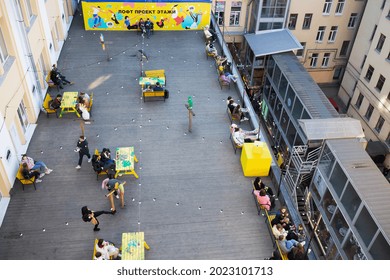 People In Open-air Cafe On Roof With Wood Flooring, Inscription - Loft Project Floors, Etagi - Saint Petersburg, Russia, April 2021