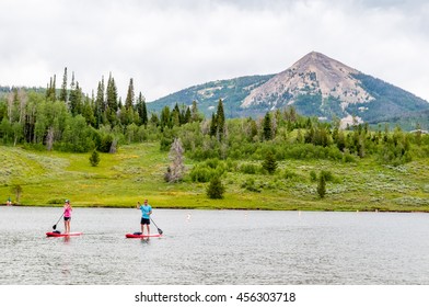 People Paddling On Canoes At Steamboat Lake