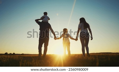 people in the park. happy family walking silhouette at sunset. mom dad and daughters walk holding hands in park. happy family childhood dream concept. parents and children sun go back silhouette