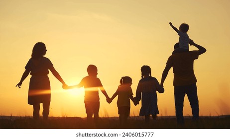 people in the park. mother and father run with baby in nature silhouette holding his hands throw up play. happy family kid dream concept. group of family children walking sun in nature silhouette - Powered by Shutterstock