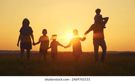 people in the park. mother and father run with baby in nature silhouette holding his hands throw up play. happy family kid dream concept sun. group of family children walking in nature silhouette - Powered by Shutterstock