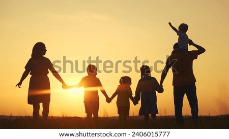 people in the park. mother and father run with baby in nature silhouette holding his hands throw up play. happy family kid dream concept. group of family children walking sun in nature silhouette
