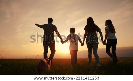 people in the park. silhouette of a big happy family on a walk with a dog at sunset in a field in nature. happy family kid dream lifestyle concept. big friendly family walk at sunset in the park