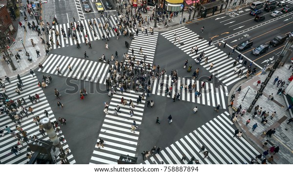 People passing the street crossing\
in Ginza district, Tokyo. Crosswalk. Intersection in\
Tokyo