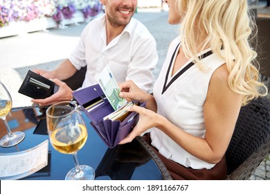 People, Payment And Finances Concept - Close Up Of Couple With Euro Cash Money In Wallets Sharing A Bill At Restaurant