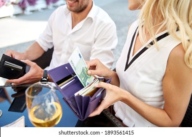 People, Payment And Finances Concept - Close Up Of Couple With Euro Cash Money In Wallets Sharing A Bill At Restaurant