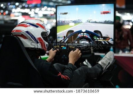 People play at Games Week, event dedicated to video games and electronic entertainment, Joy games driving gamer. (VR games)