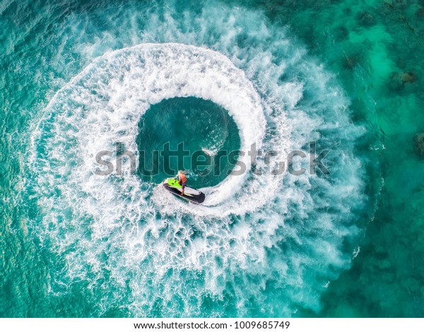 People are playing a jet ski in the sea.Aerial\
view. Top view.amazing nature background.The color of the water and\
beautifully bright. Fresh freedom. Adventure day.clear turquoise at\
tropical beach.