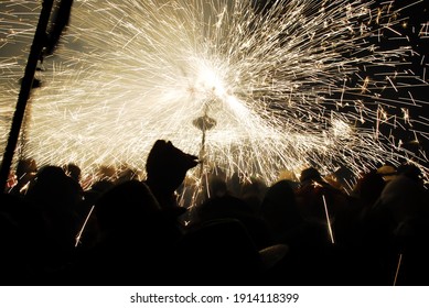 People playing with pyrotechnics in the street at a village. People having fun