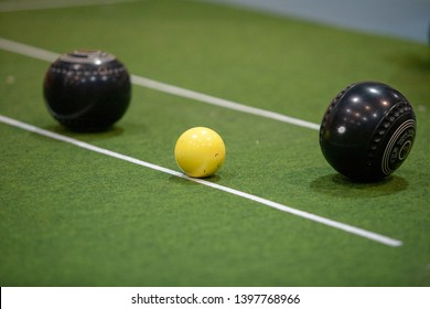 People playing the sport bowls on an indoor mat