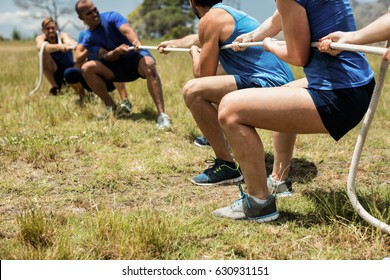 People playing tug of war during obstacle training course in boot camp - Shutterstock ID 630931151