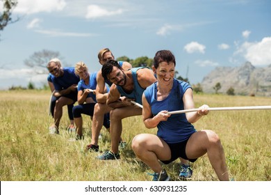 People playing tug of war during obstacle training course in boot camp - Powered by Shutterstock