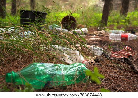 People polluting Earth, littered green forest, empty bottles lying on earth, environment pollution, start recycling, protect our planet