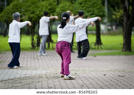 People practising tai chi in the park