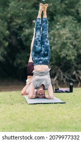 People Practising Yoga In A Reverse Position In A Park