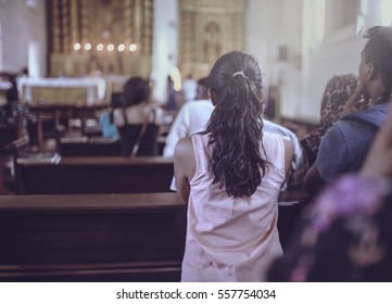 People Pray Inside The Church Facing Towards Altar. 