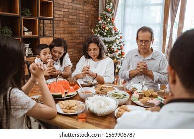 people praying before having their lunch. christian family pray - Powered by Shutterstock