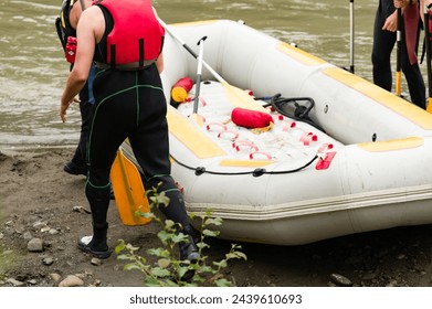 People prepare for rafting, mountain rafting for tourists. The athlete is waiting for the team on the bank of the river. - Powered by Shutterstock