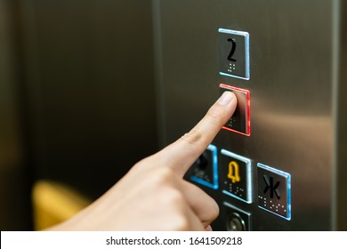 People Pressing The Button In The Lift And Select The First Floor By Using The Forefinger. Elevator Control Panel In Small Building Close Up. Bell Alphabet On The Button In The Passenger Lift.