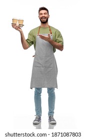 People, Profession And Job Concept - Happy Smiling Barman In Apron Holding Takeaway Coffee Over White Background