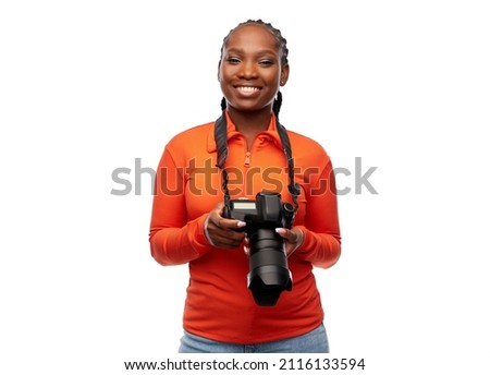 people, profession and photography concept - happy young woman with digital camera over white background