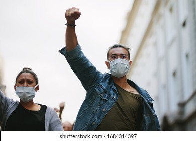 People protesting and giving slogans in a rally. Group of activists protesting against the government in the city. - Shutterstock ID 1684314397