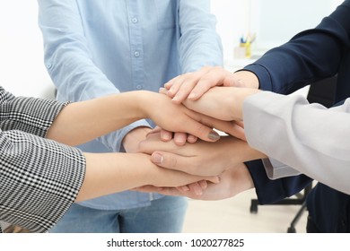 People putting hands together as symbol of unity - Shutterstock ID 1020277825