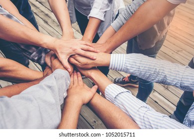People putting their hands together. Friends with stack of hands showing unity and teamwork.