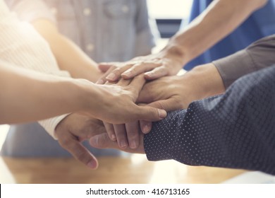 people putting their hands together for united, cooperation and teamwork concept, selective focus and vintage tone - Shutterstock ID 416713165