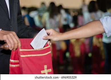 People Putting Tithing Into Velvet Offering Bag In Church 