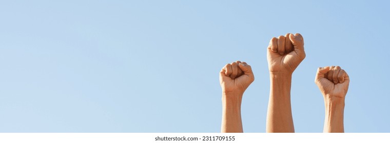 People raise fists, sky background. Power of teamwork and Competition concept. copy space - Shutterstock ID 2311709155