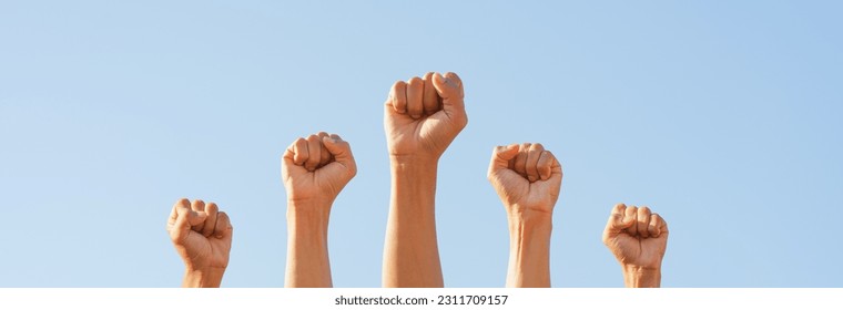 People raise fists, sky background. Power of teamwork and Competition concept