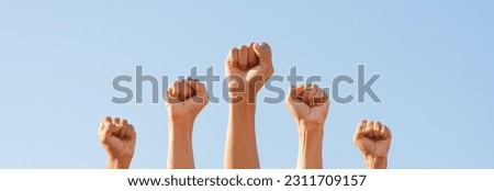 People raise fists, sky background. Power of teamwork and Competition concept