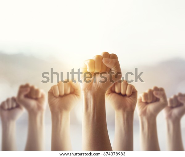 People\
raised fist air fighting for their rights with sunlight effect, \
labor movement, election movement, copy\
space