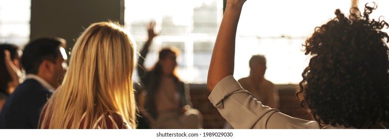 People raised their hand in a meeting - Shutterstock ID 1989029030