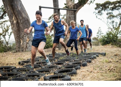 People receiving tire obstacle course training in boot camp