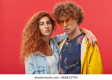 People, Relationships, Style, Fashion And Modern Lifestyle. Studio Portrait Of Two Male And Female Best Friends With Ginger Hair Standing Close To Each Other, Girl With Freckles Hugging Man In Shades