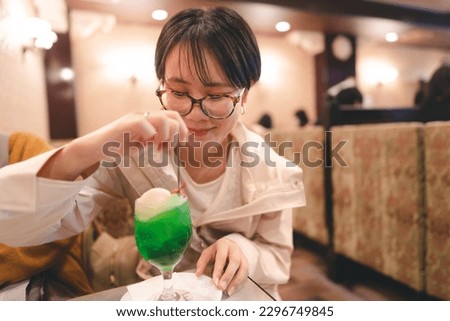 People relax in kissaten japan style retro coffee shop. Young adult asian woman drinking icecream melon soda trendy japanese teenager people menu.