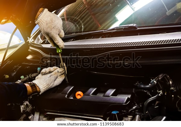 People are repair a car Use a wrench and a
screwdriver to work.Safe and confident in driving. Regular
inspection of used cars. It is very well
done.
