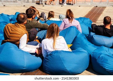 People Rest On Bean Bags In The Park Area. Summer Outdoor Concert Venue. Unrecognizable Person. Close-up