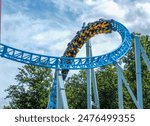 People ride a roller coaster at an amusement park